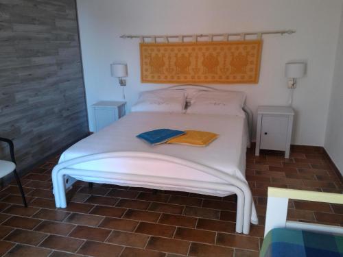 塔瑙内拉Residenza Vacanze的卧室配有白色的床和两张桌子