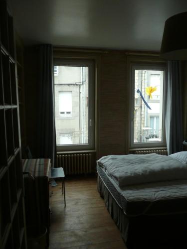格朗维尔81 Rue des Juifs的一间卧室设有2扇窗户、1张床和1张桌子