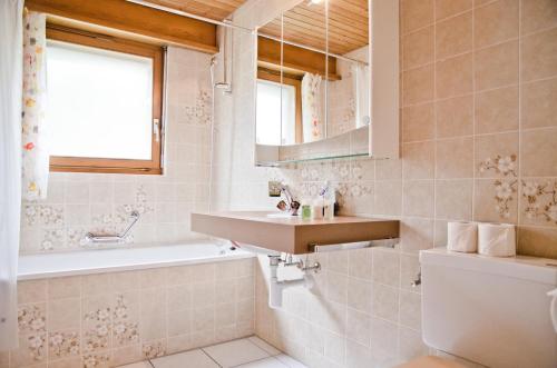 格尔兹维尔Apartment Aare 3.5 by GriwaRent AG的一间带水槽、浴缸和卫生间的浴室
