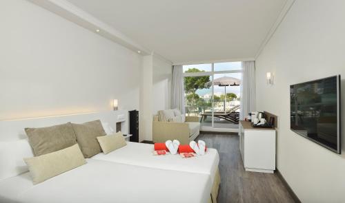 马盖鲁夫巴巴多斯索尔酒店的一间白色的卧室,配有床和客厅