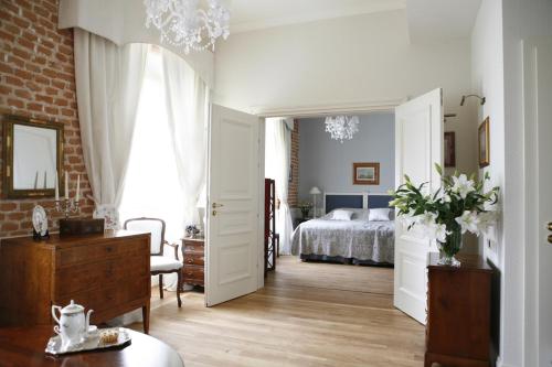 克拉科夫德沃科斯祖泽克酒店的一间卧室配有一张床和一个梳妆台,另一间卧室配有床罩。