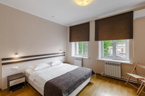 喀山卡拉特酒店的一间卧室设有一张床和两个窗户。
