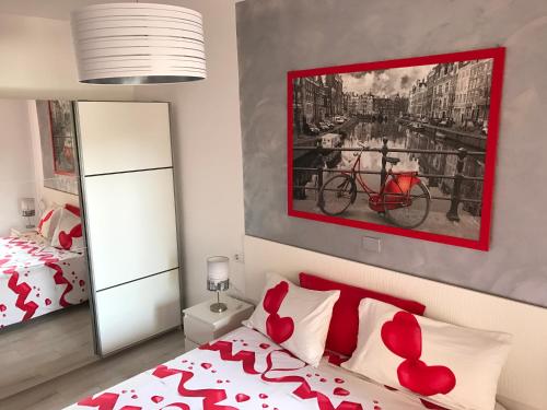 阿德耶Bonito apartamento Complejo Orlando的一间卧室配有一张带红色枕头的床和一幅画
