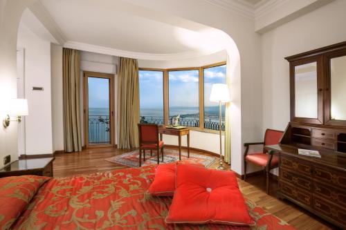陶尔米纳迪奥多罗别墅酒店的一间卧室配有一张大床、一张书桌和窗户。