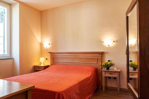 Martina OlbaAlbergo Minetto的一间卧室配有红色的床和两张桌子
