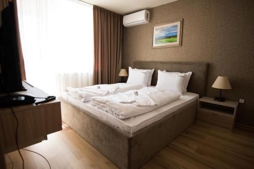 帕纳久里什泰Court Inn的卧室配有一张带白色床单和枕头的大床。