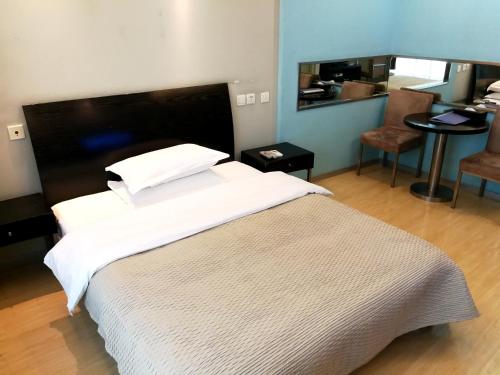 上海阿卑斯酒店公寓-新时空商务广场（阿卑斯中山公园1）的卧室配有一张白色的大床和一张桌子