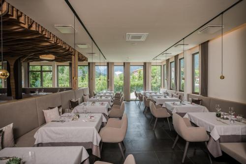 多比亚科贝尔维尤公园酒店的餐厅设有白色的桌椅和窗户。
