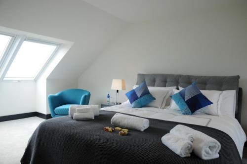 因奇Seascapes的一间卧室配有一张大床、毛巾和蓝椅