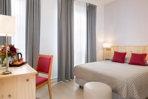 巴黎功博斯特尔酒店的一间卧室配有一张床、一张桌子和一把椅子