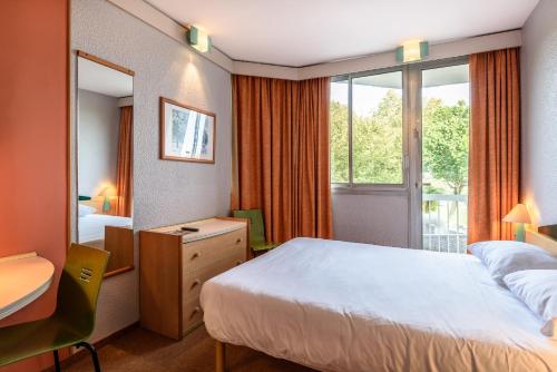 达克斯米拉多尔酒店的配有一张床、一张书桌和一扇窗户的酒店客房