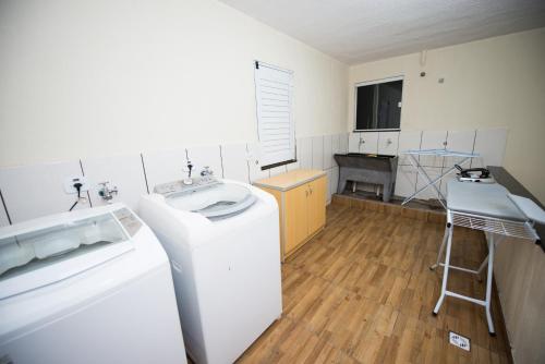 伊瓜苏Vila Dumont no Centro de Foz的厨房配有水槽和洗衣机