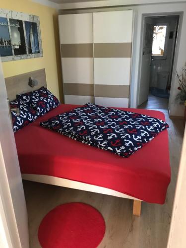 罗斯托克Kompass的一间卧室配有红色的床和红色地毯