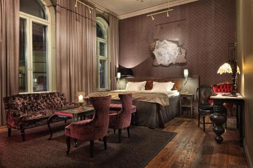 于默奥斯托拉酒店的一间卧室配有一张床、一张沙发和一张桌子