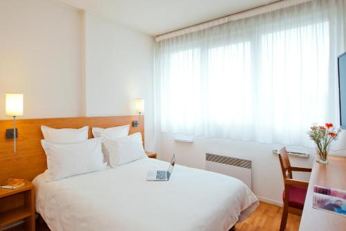 里昂塞祖尔阿菲尔里昂圣尼克拉酒店的卧室设有一张白色大床和一扇窗户。
