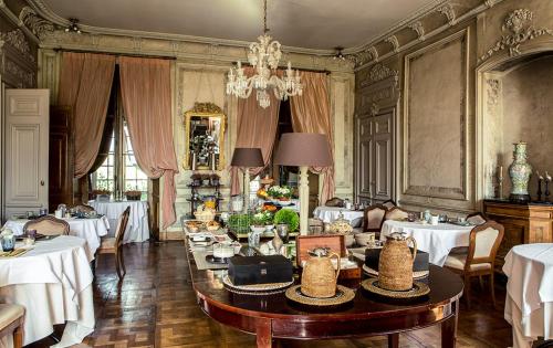 尚皮涅布瑞特尔斯城堡酒店的一间带桌椅和吊灯的用餐室