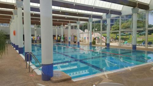 凯撒利亚Neot Golf Caesarea Garden Apartment的大楼内一个蓝色的大型游泳池