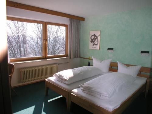 阿克博格洪堡德-豪斯酒店的一间卧室配有一张带白色床单的床和一扇窗户。