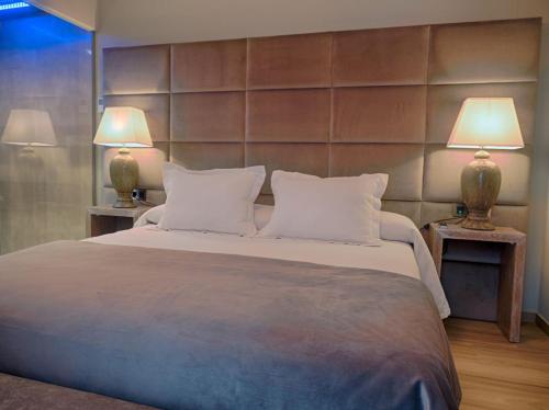 Adamuz圣安德烈斯旅馆的一间卧室配有一张大床和两盏灯
