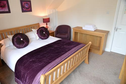 弗罗姆The Foresters的一间卧室配有一张大床,上面有紫色枕头
