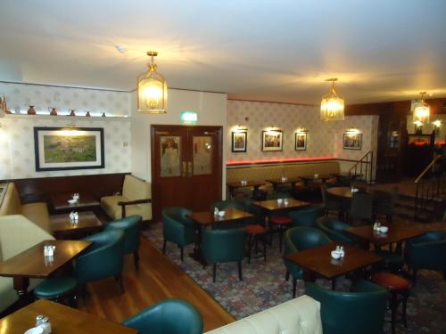 坦普尔莫尔Templemore Arms Hotel的餐厅设有木桌和蓝色椅子