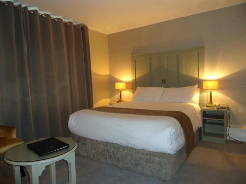 坦普尔莫尔Templemore Arms Hotel的酒店客房设有一张大床和一张桌子。