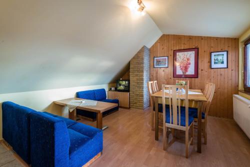特尔乔夫Chalupa LUKA Terchová的一间配备有蓝色沙发和一张桌子的用餐室
