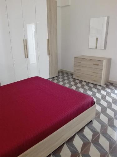 曼杜里亚Casa davide的一间卧室配有红色的床和梳妆台