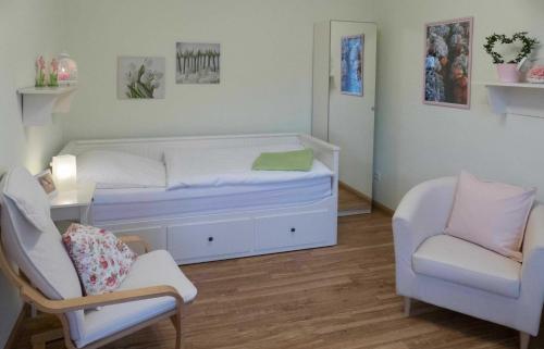 路德斯塔德·威特比Pension im Adventhaus的一间卧室配有一张床、一把椅子和一张沙发