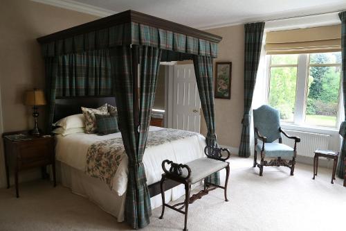 奈恩卡尔纳赫之家旅馆的一间卧室配有一张天蓬床和一把椅子