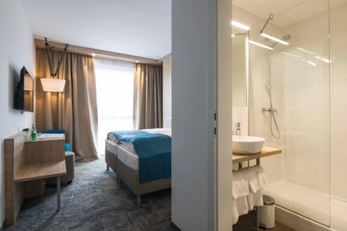 圣珀尔滕达斯阿尔弗雷德酒店的一间卧室配有一张床,浴室设有水槽