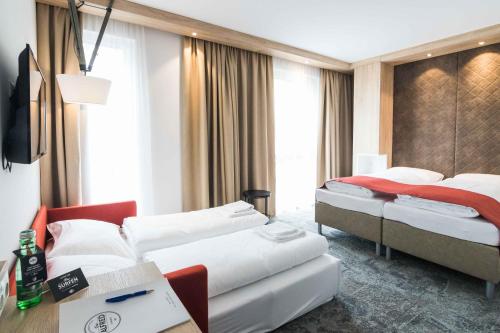 圣珀尔滕达斯阿尔弗雷德酒店的一间酒店客房,设有两张床和电视