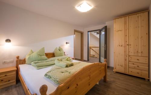 瑟尔Ferienwohnung Lederer的一间卧室配有一张带绿色枕头的木床。