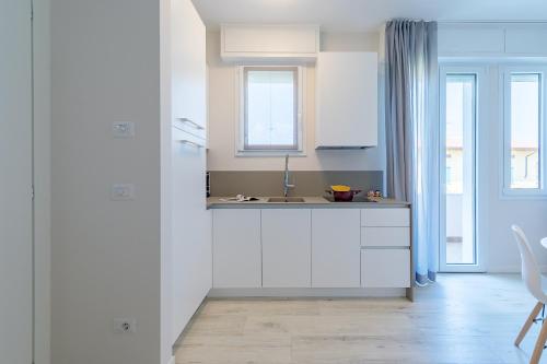 西尔米奥奈Appartamento Valeria by Wonderful Italy的厨房配有白色橱柜和水槽