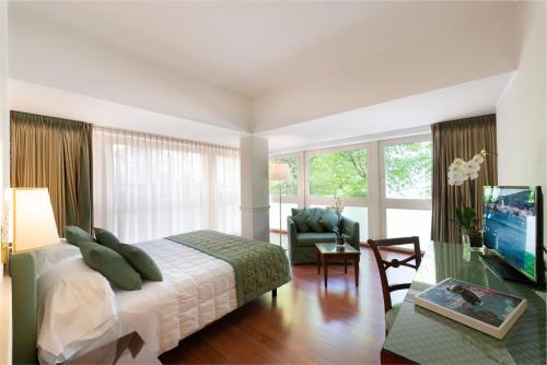 科莫巴格尔达高级酒店的一间卧室设有一张床和一间客厅。