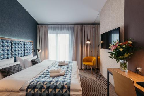 克拉科夫Avena Boutique Hotel by Artery Hotels的酒店客房设有一张大床和一台电视。