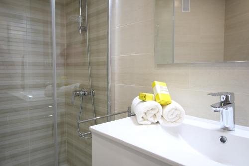 马拉加Del Parque Flats - Zamarrilla的带淋浴和毛巾水槽的浴室