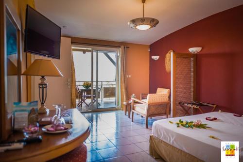 Bandrélé萨库里酒店的酒店客房设有一张床和一张桌子及一台电视