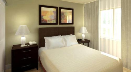 亚基马礁石酒店 的一间卧室配有一张床、两盏灯和一个窗户。