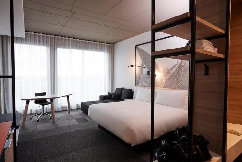 布罗瑟德Hôtel Escad Quartier DIX30的配有一张床和一张书桌的酒店客房