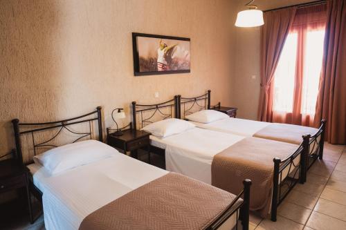 梅萨雷亚维拉丹内齐斯的酒店客房设有三张床和窗户。