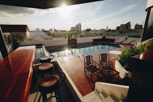 圣克鲁斯阿雷纳尔酒店的大楼内带椅子的屋顶甲板和游泳池