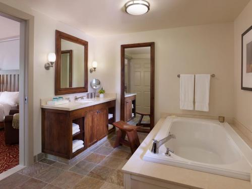 圣海伦娜丰收酒店的一间带大浴缸、水槽和镜子的浴室