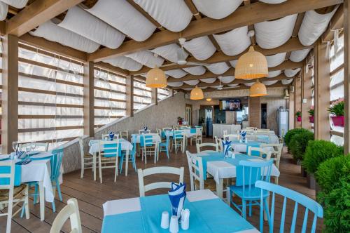 金沙白鸽别墅酒店的一间设有蓝色桌子和白色椅子的餐厅