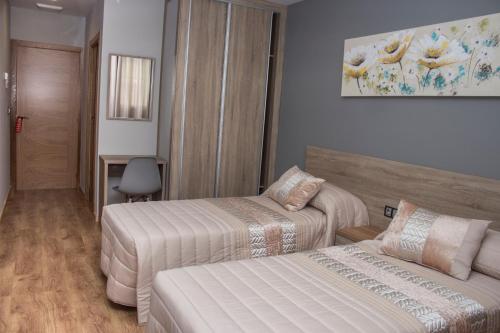 巴雷罗斯O Vendaval Hostal Restaurante的酒店客房,设有两张床和一张沙发