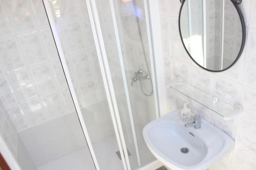 蓬特德乌梅O Cruceiro的带淋浴、盥洗盆和镜子的浴室