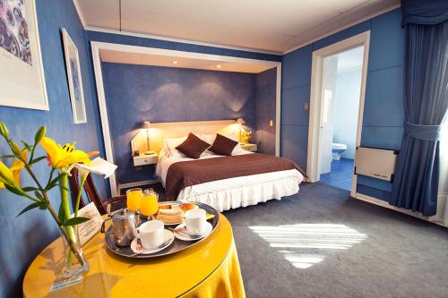 维纳德马Hotel Albamar的酒店客房,配有床和餐桌,上面有食物