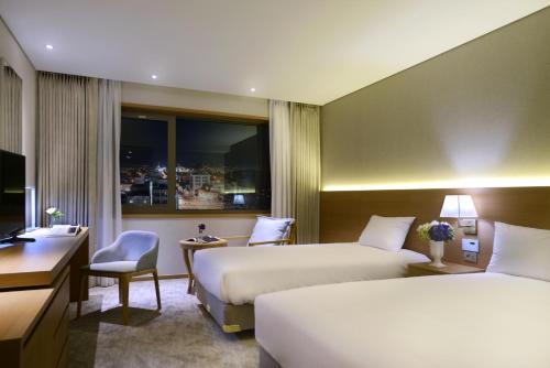 济州市阿斯塔尔酒店的酒店客房配有两张床和一张书桌