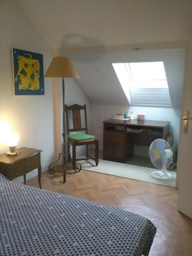 奥尔沃Chantilly的一间卧室配有一张床、一张书桌和一个窗户。