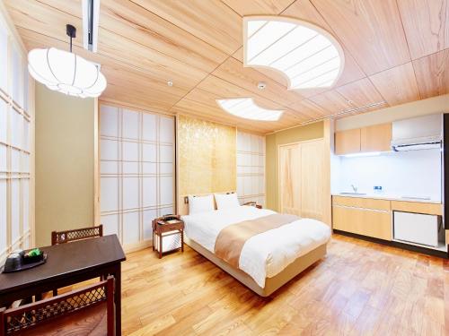 京都日升套房酒店的一间带大床的卧室和一间厨房